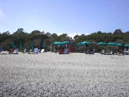 Blick vom Meer aus auf die Liegestühle und Sonnenschirme am Strand